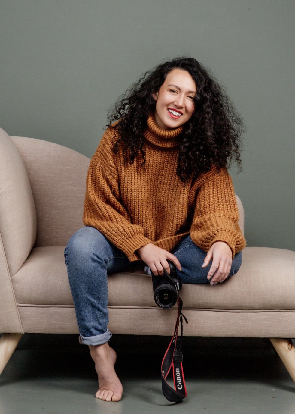 Melanie today, laughing on a sofa with her camera